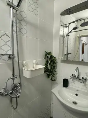 a white bathroom with a sink and a shower at The Master and Margarita Apartment, Майстора и Маргарита 2 in Burgas City