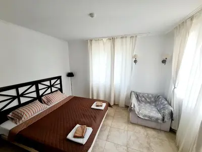 a bedroom with a large bed and a chair at Apartment Almi - The Cliff Obzor in Obzor