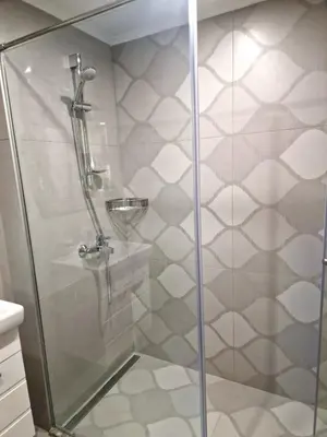a shower with a glass door in a bathroom at Луксозен Апартамент в Модерна сграда -Молимаркс Делукс Апартамент Бургас in Burgas City