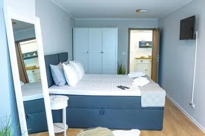a small bedroom with a bed and a mirror at Луксозен Апартамент в Модерна сграда -Молимаркс Делукс Апартамент Бургас in Burgas City