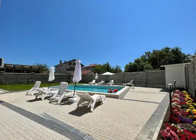a patio with chairs and a swimming pool at Апартаменти Астрея Обзор - Apartments Astrea Obzor in Obzor