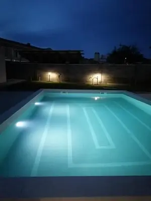 a swimming pool lit up at night at Апартаменти Астрея Обзор - Apartments Astrea Obzor in Obzor