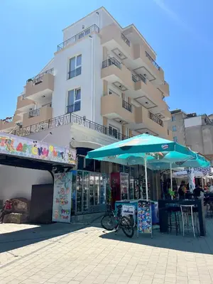 a building with two blue umbrellas in front of it at Апартаменти Астрея Обзор - Apartments Astrea Obzor in Obzor