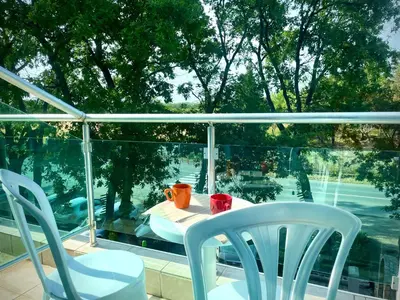 a table and chairs on a balcony with a window at Budget First Sea Line Apt. FLORA in Pomorie