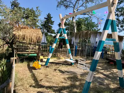 a swing set in a yard with a fence at Budget First Sea Line Apt. FLORA in Pomorie