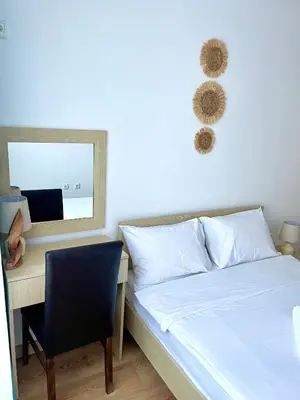 a bedroom with a bed and a desk and a mirror at Budget First Sea Line Apt. FLORA in Pomorie