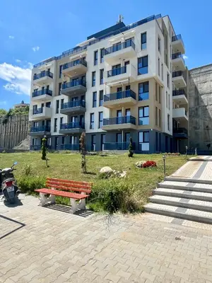 a large apartment building with a bench in front of it at Апартамент Бийч Вю Обзор - Apartment Beach View Obzor in Obzor