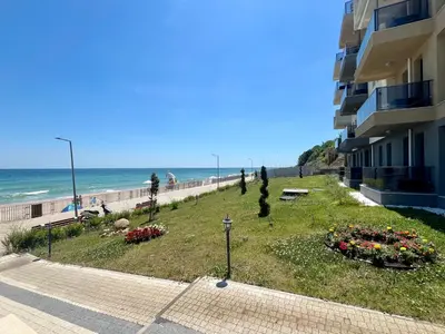a building on the beach next to the ocean at Апартамент Бийч Вю Обзор - Apartment Beach View Obzor in Obzor