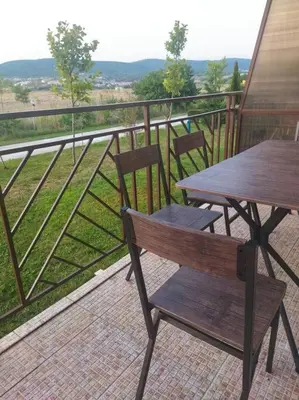 a wooden bench sitting on a balcony with a table at Lovely bright studio on Sunny Beach in Sunny Beach