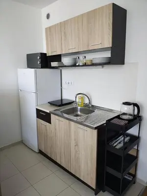 a kitchen with a sink and a white refrigerator at Lovely bright studio on Sunny Beach in Sunny Beach
