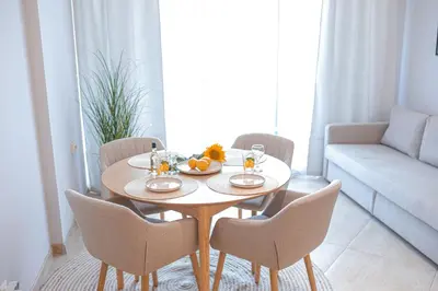 a table with a bowl of fruit on it in a living room at Дизайнерско Студио в Модерна сграда -Молимаркс Делукс Студио Бургас in Burgas City