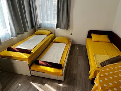 two beds in a room with yellow sheets at Romance in Pomorie