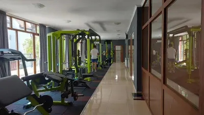a gym with a row of treadmills and machines at COCO Coworking & Coliving in Aheloy