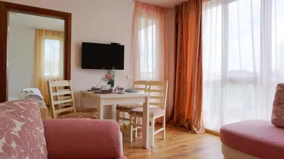 a living room with a table and a tv at Апартамент Атлантик Бяла - Apartment Atlantic Byala in Byala