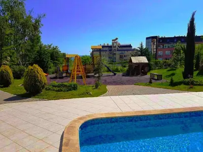 a swimming pool in a park with a playground at Апартамент Атлантик Бяла - Apartment Atlantic Byala in Byala