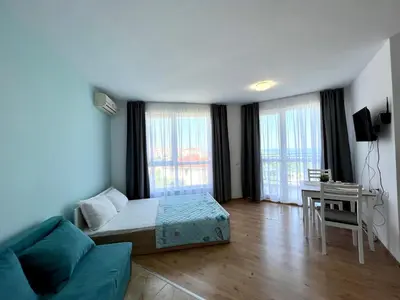 a bedroom with a bed and a desk in a room at Студио Галерия - Studio Galeria in Byala