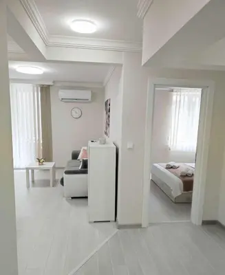 a white room with a bed and a refrigerator at DiP HOME APARTMENTS in Pomorie