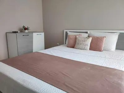 a bedroom with a bed with pink and white pillows at DiP HOME APARTMENTS in Pomorie