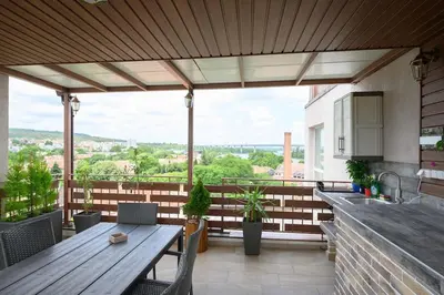 a patio with a wooden table and a kitchen at Sunset Luxury Apartment in Varna City