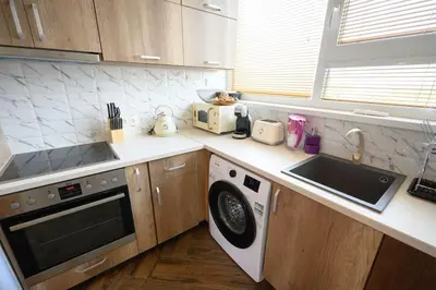 a kitchen with a sink and a washing machine at Sunset Luxury Apartment in Varna City
