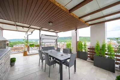 a patio with a table and chairs on a balcony at Sunset Luxury Apartment in Varna City