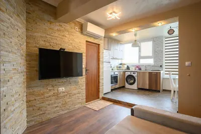 a living room with a television on a brick wall at Sunset Luxury Apartment in Varna City