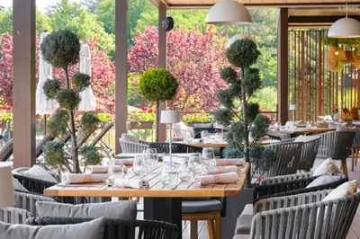 a dining room with tables and chairs and flowers at Sea Bliss Retreat -Santa Marina - Sozopol in Sozopol