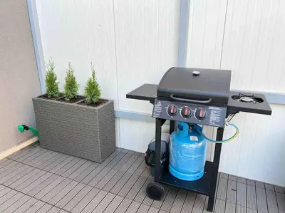 a bbq grill with a blue water bottle on it at Villi’s Home in Burgas City