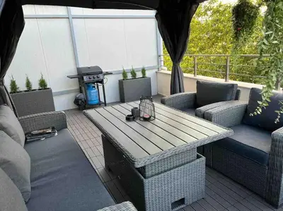 a patio with a table and chairs and a grill at Villi’s Home in Burgas City