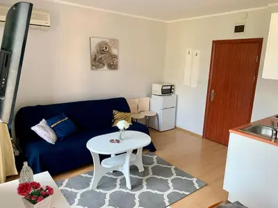 a living room with a blue couch and a table at Apartament Esperanza in Sunny Beach