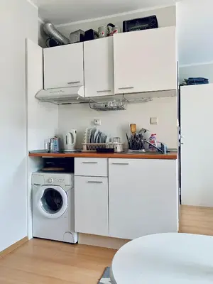 a kitchen with white cabinets and a washing machine at Apartament Esperanza in Sunny Beach