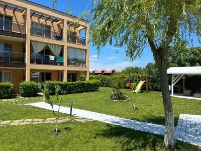 a large apartment building with a tree in the yard at Sozopolis Hills - B1 - 3-room apart - 10 min from the beach in Sozopol
