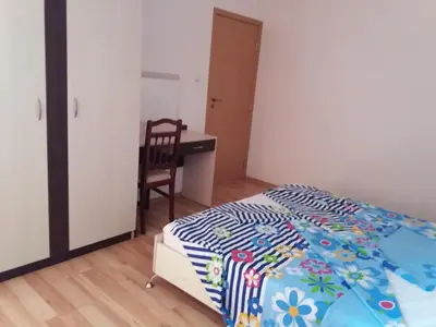 a bedroom with a bed and a desk with a chair at Апартамент в комплекс Зора 9A in Sozopol