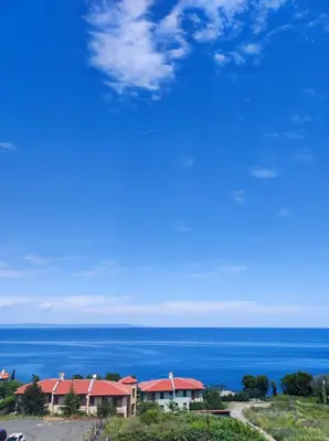 a house on a hill with the ocean in the background at Апартамент в комплекс Зора 9A in Sozopol