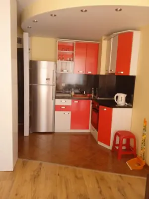 a kitchen with red cabinets and a stainless steel refrigerator at APARTMENT 8 Primorsko АПАРТАМЕНТ 8 Приморско in Primorsko