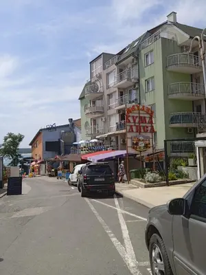 a parking lot with cars parked in front of a building at APARTMENT 8 Primorsko АПАРТАМЕНТ 8 Приморско in Primorsko