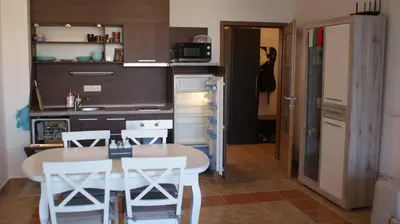 a kitchen with a table and chairs in a room at Cozy apartment with sea view and free parking in Pomorie