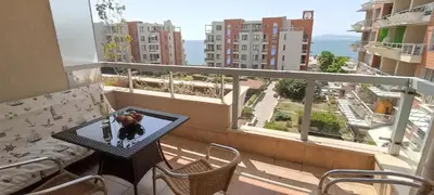 a balcony with a table and a view of a city at Cozy apartment with sea view and free parking in Pomorie