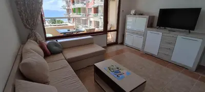 a living room with a couch and a flat screen tv at Cozy apartment with sea view and free parking in Pomorie