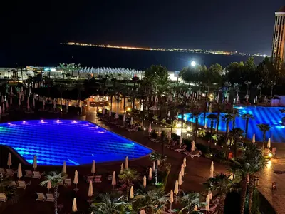 a pool with blue lights in a city at night at Sunny Majestic Private Apartment in Sunny Beach