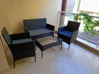 a balcony with chairs and a table and a window at Harmani Beach Apartment 4 in Sozopol