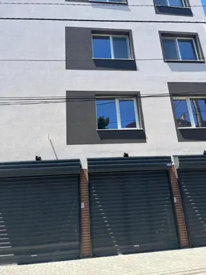 two garage doors on the side of a building at Zagorovi -1 SP apartments in Burgas City