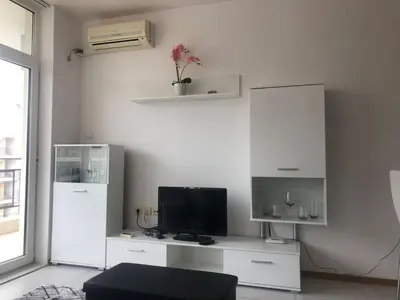 a living room with a tv on a white desk at Lovely 3 Room Apartment new furnished Kamelia Sunny Beach in Sunny Beach