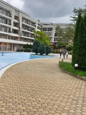 a brick walkway in front of a large building at Lovely 3 Room Apartment new furnished Kamelia Sunny Beach in Sunny Beach