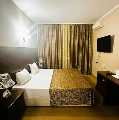 a hotel room with a bed and a television at Studio Festa Pomorie in Pomorie