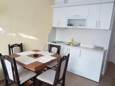 a kitchen with a table with chairs and a microwave at Apartament Iglika in Primorsko