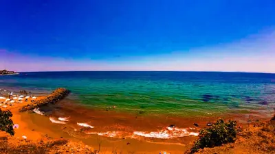 a beach with a bunch of people in the water at William's apartments - fifth amazing studio in Sveti Vlas