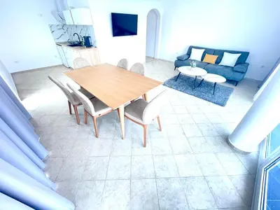a living room with a wooden table and chairs at Villa Mare Blu in Sozopol