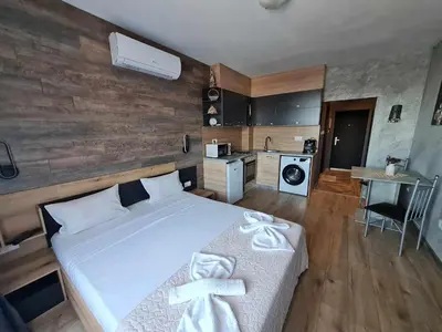 a bedroom with a large bed and a kitchen at MitProt Panorama Bay 2 Studio 206 in Sveti Vlas