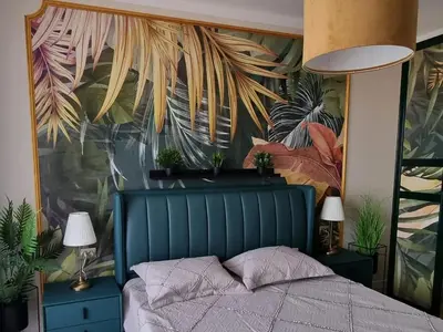 a bedroom with a blue bed with plants on the wall at Golden leaf, swimming pool view in Ravda